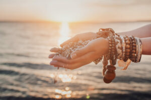 A woman with sand falling through her hands.summer background