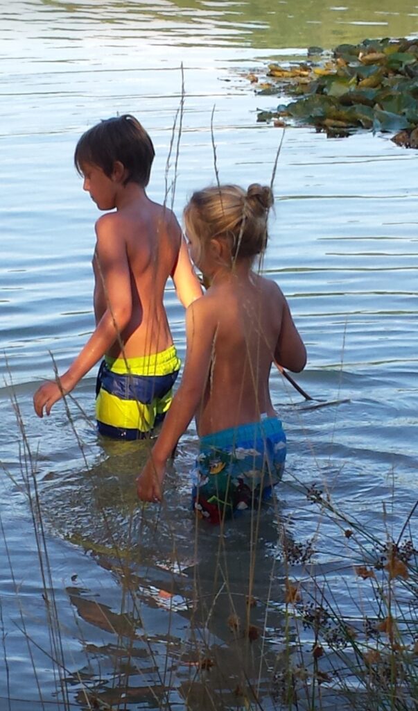zwei Kinder baden im See